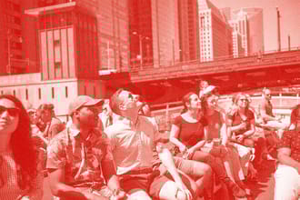 People on a boat looking up at buildings