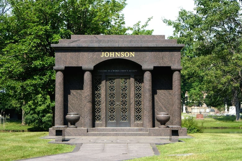 Large dark brown crypt with 4 columns and 2 urns.